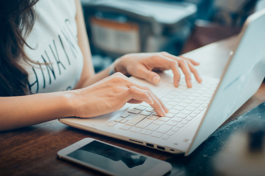 Moodle - Vue coupée d'une femme tapant sur le clavier d'un ordinateur portable