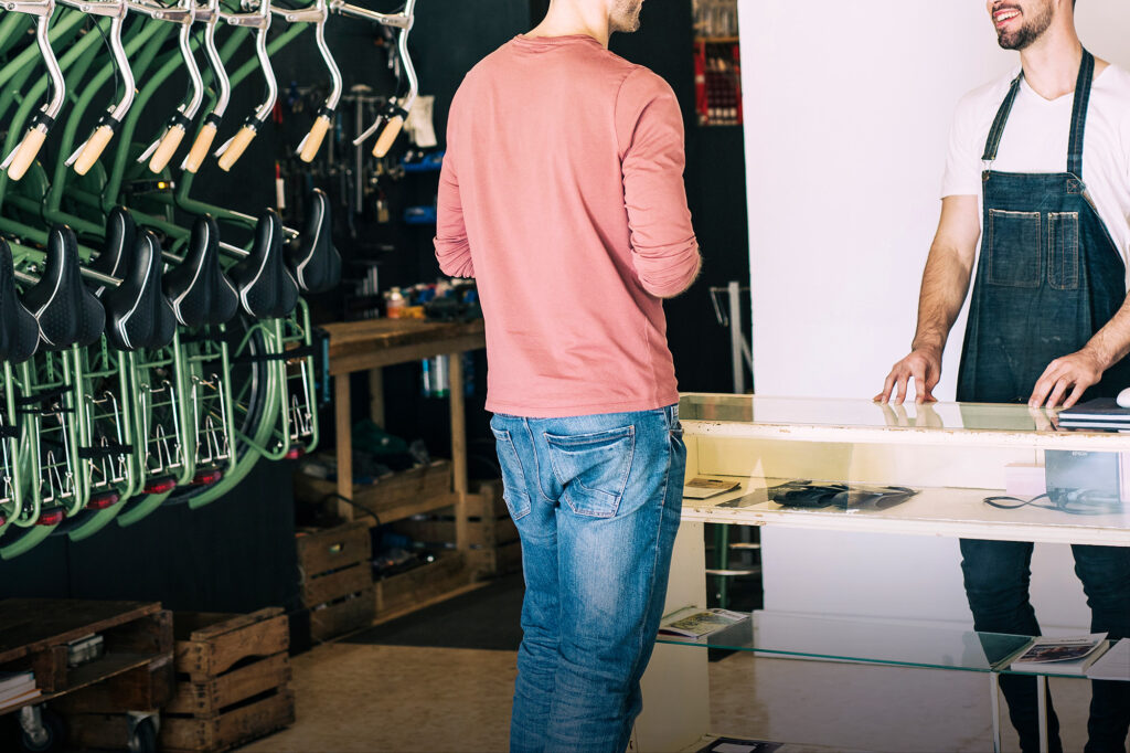 TP Vendeur sport - Un client au comptoir face au vendeur dans une boutique de vélos