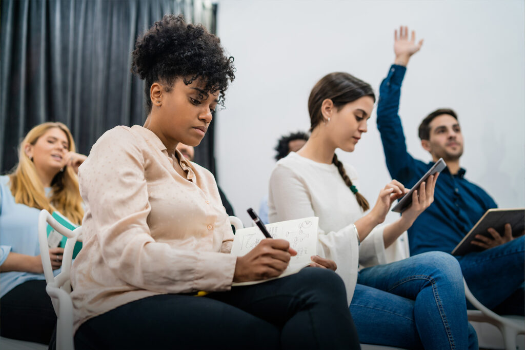 Tuteur FOAD - Personnes assises prenant des notes de manière concentrée