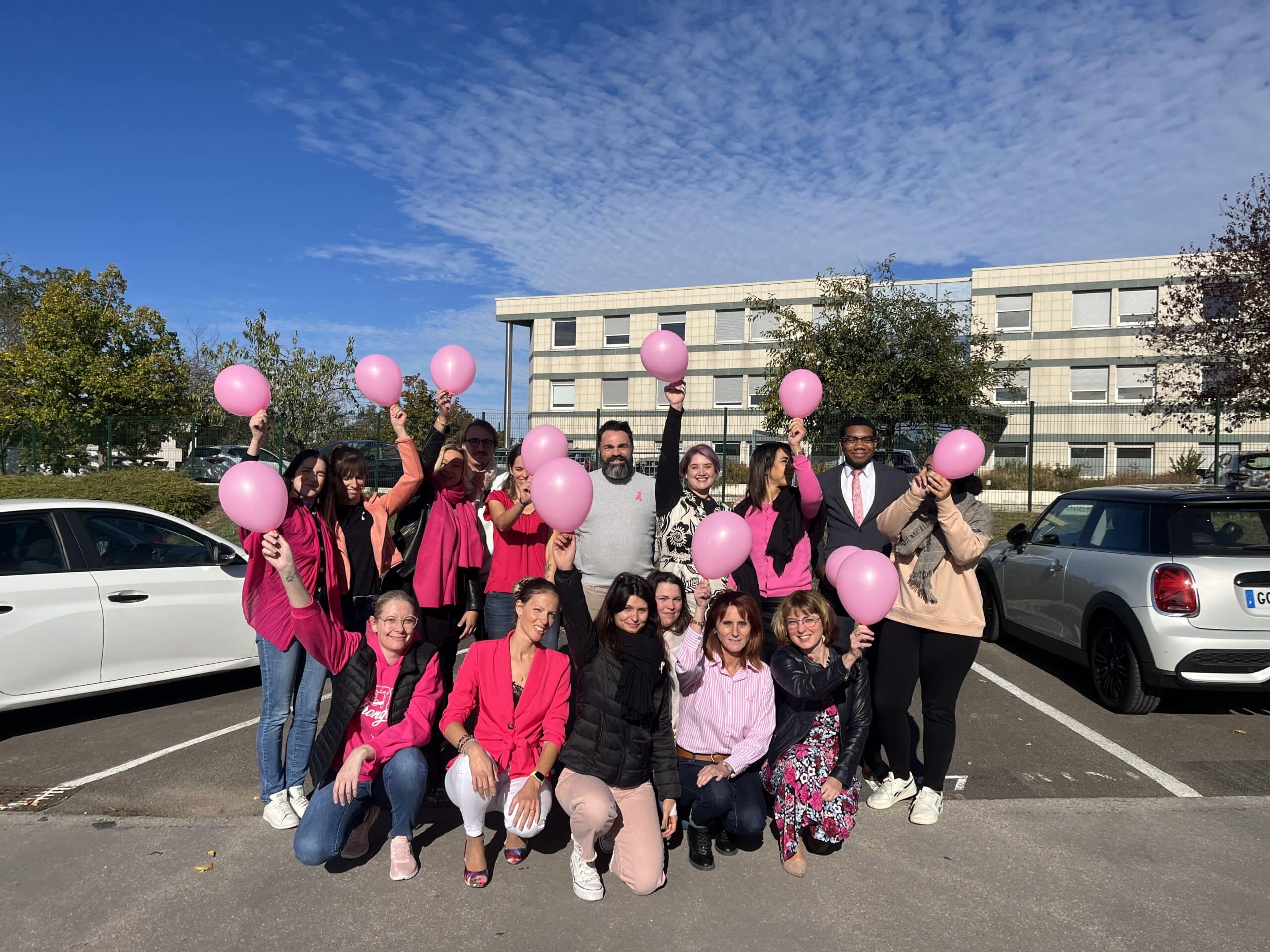 Octobre rose : les employé(e)s de SELFORME, vêtus d'accessoires roses, tiennent des ballons roses et prennent la pose