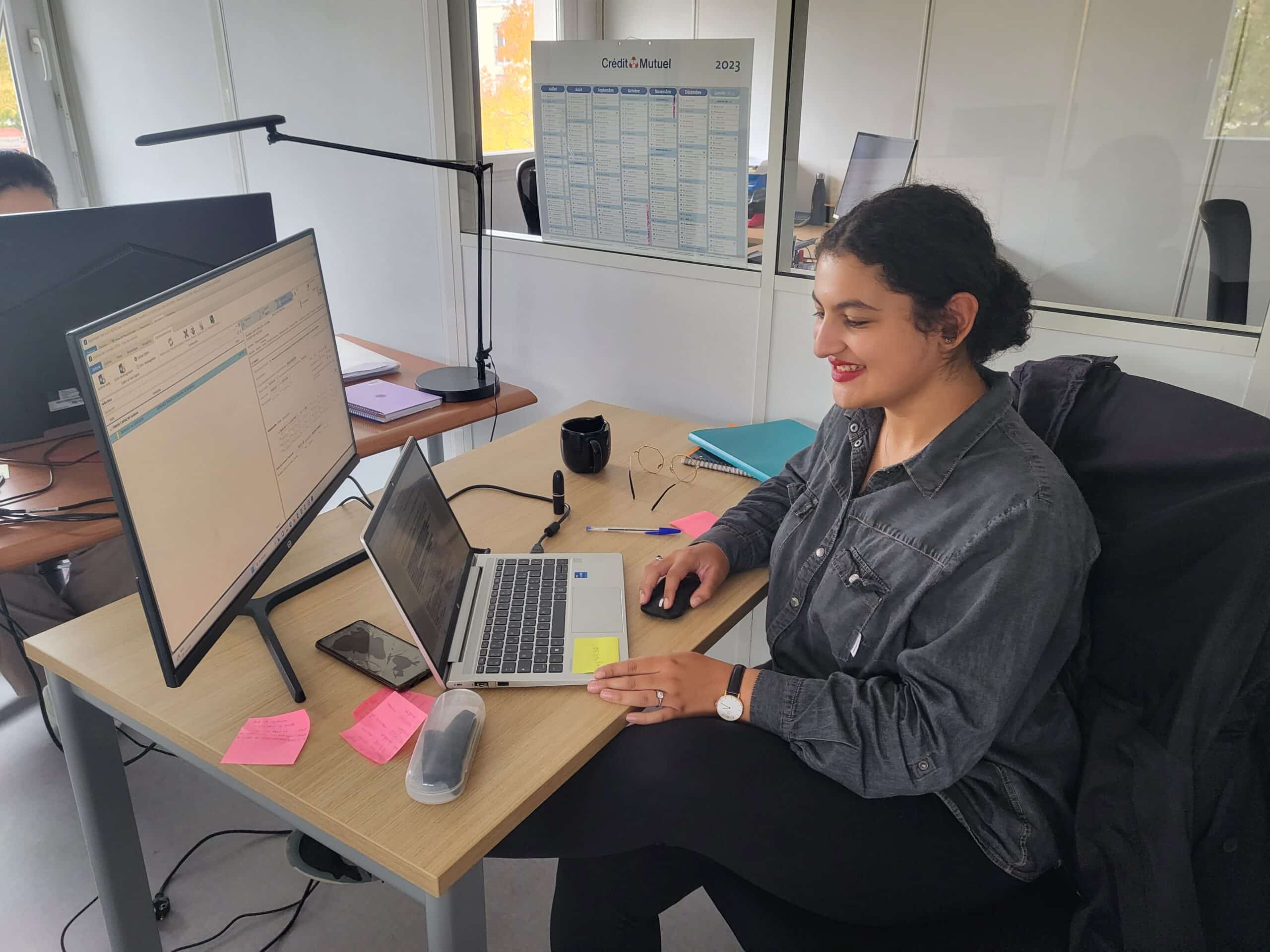 Ines Taha assise à son bureau en train de taper à l'ordinateur